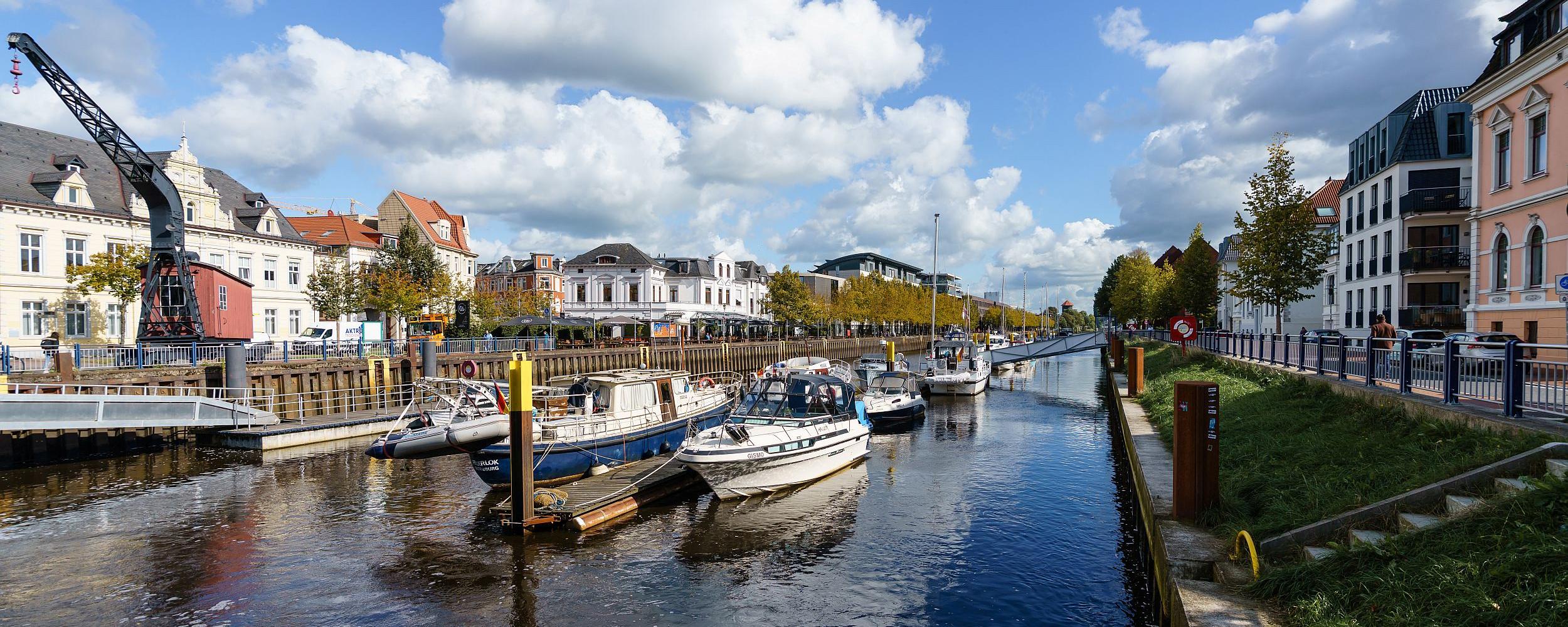 Blick auf den Oldenburger Hafen mit historischem Kran, Booten und Uferbebauung